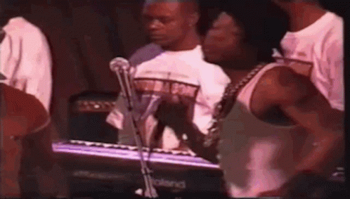 Man in White Tank Top Playing Keyboard for Crowd