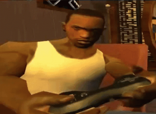 Man in White Tank Top Playing Video Game on Couch