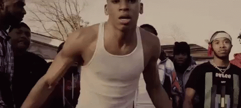 Man In White Tank Top Standing In Crowd GIF