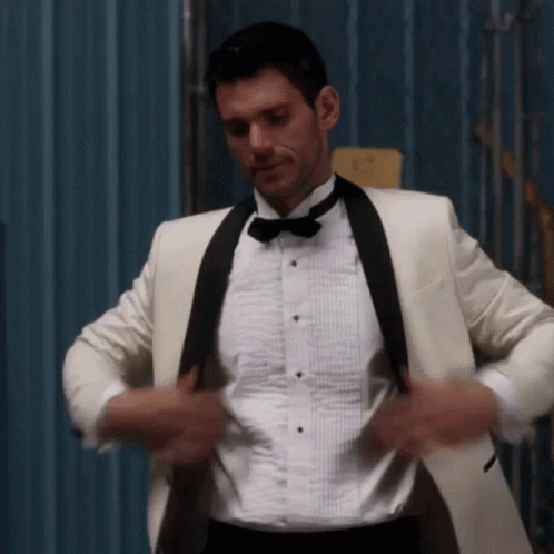 Man in White Tuxedo Adjusting Jacket