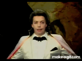 Man in White Tuxedo With Bat on Jacket