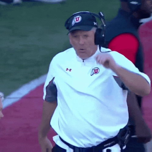 Man in White Under Armour Shirt and Hat With Letter U