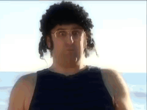Man in Wig and Glasses on Beach