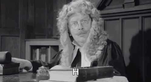 Man in Wig and Glasses Sitting at Table