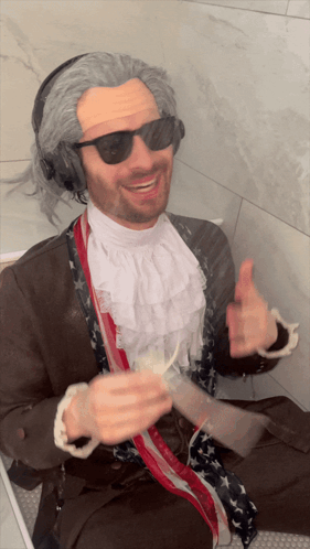 Man in Wig and Headphones Thumbs Up