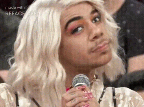 Man in Wig Holding Microphone Making Face