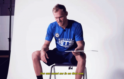 Man in Winnipeg Jets Shirt Sitting on Chair