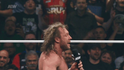 Man in Wrestling Ring Holding AEW Microphone