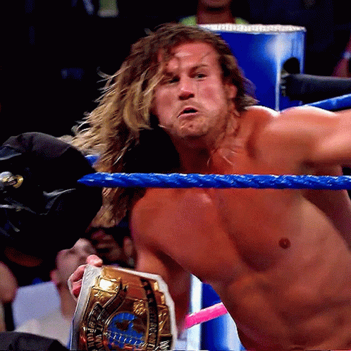 Man in Wrestling Ring With Gold World Heavyweight Champion Belt