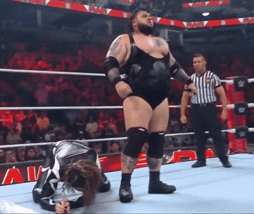 Man in Wrestling Ring With Referee and Sign Saying A