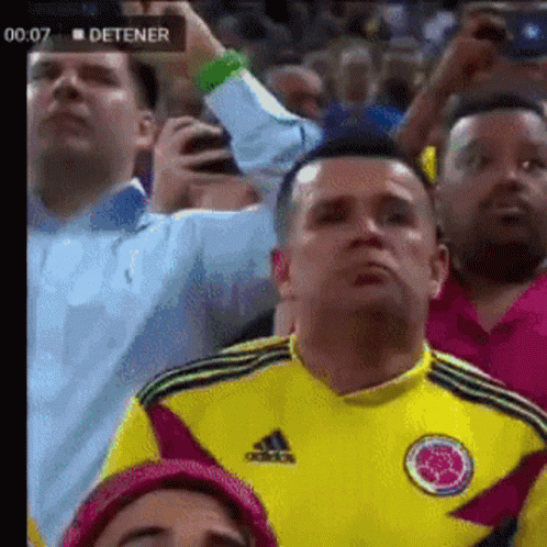 Man in Yellow Adidas Shirt Watching Soccer