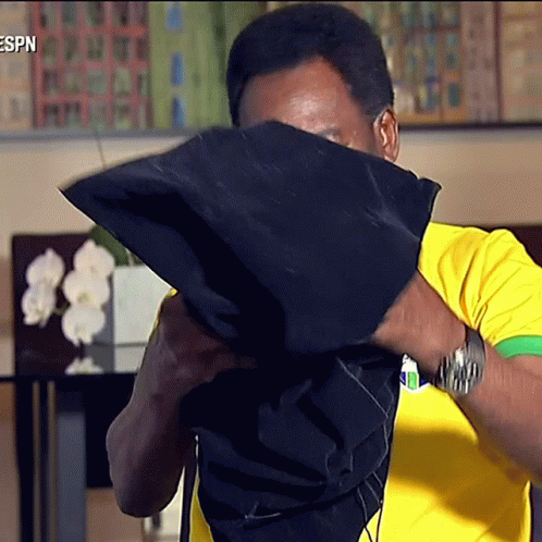 Man in Yellow and Green Shirt Covering Face