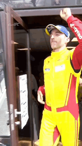 Man in Yellow and Red Racing Suit at Door