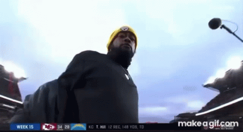 Man in Yellow Beanie at Microphone in Stadium