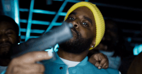 Man in Yellow Beanie Holding Gun
