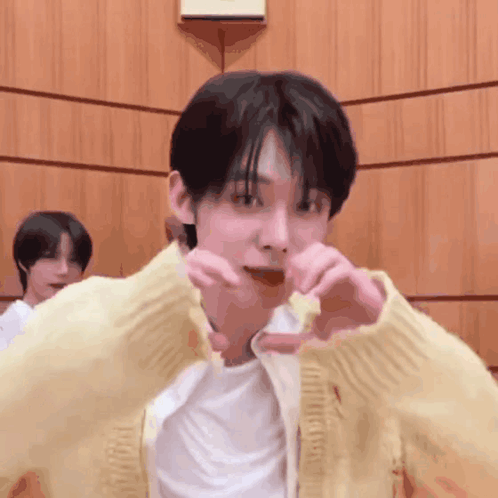 Man In Yellow Cardigan Making Heart Shape GIF