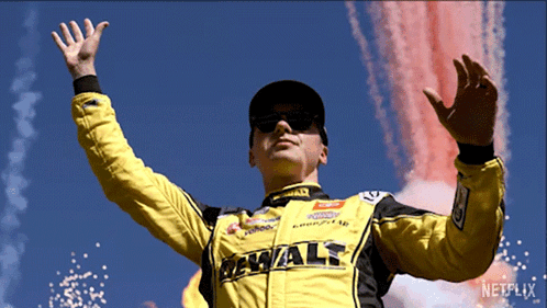 Man in Yellow DeWalt Jacket in Front of Fireworks