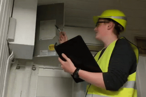 Man In Yellow Hard Hat And Safety Vest Holding Clipboard GIF
