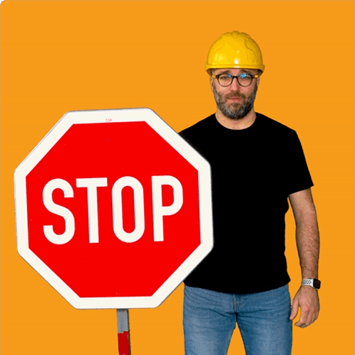 Man in Yellow Hard Hat Holding Stop Sign