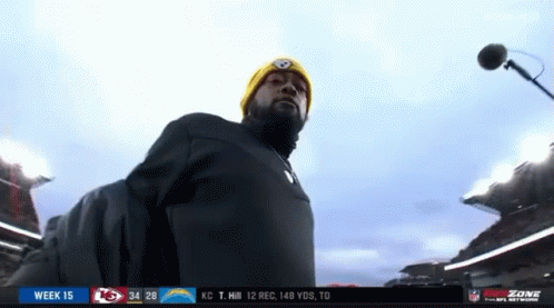 Man in Yellow Hat at Microphone in Stadium
