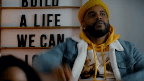 Man in Yellow Hat with Sign Build a Life We Can