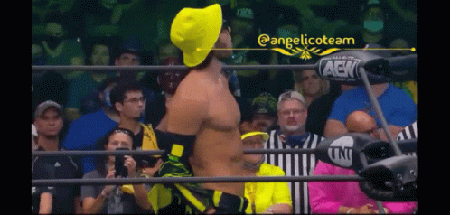 Man in Yellow Hat Wrestling Ring with Fans