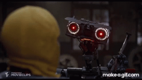 Man in Yellow Hood Watching Robot with Red Lights