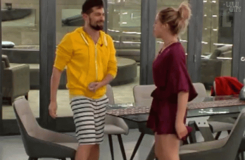 Man in Yellow Hoodie Next to Woman in Red Dress