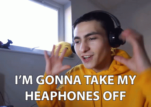 Man in Yellow Hoodie Taking Off Headphones
