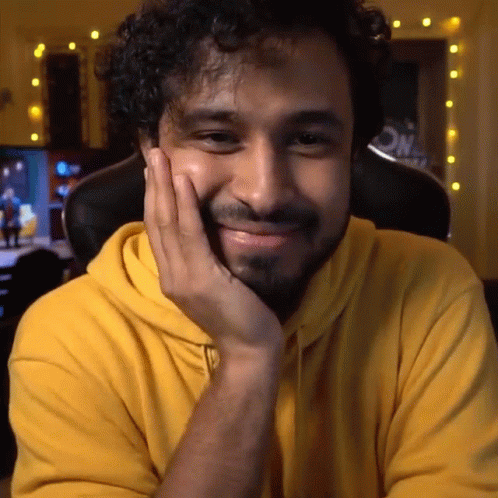 Man In Yellow Hoodie With Hand On Face GIF