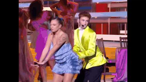 Man in Yellow Jacket Dancing With Woman in Blue Dress