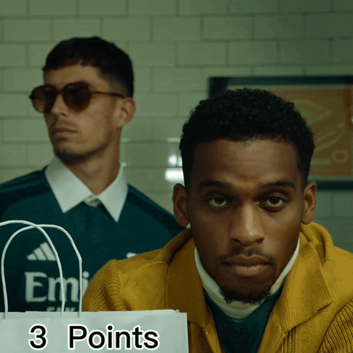 Man in Yellow Jacket Holding 3 Points Bag