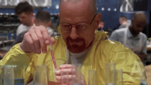 Man in Yellow Jacket Pouring Liquid Into Glass With Straw