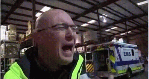 Man in Yellow Jacket Screaming in Front of EMS Ambulance