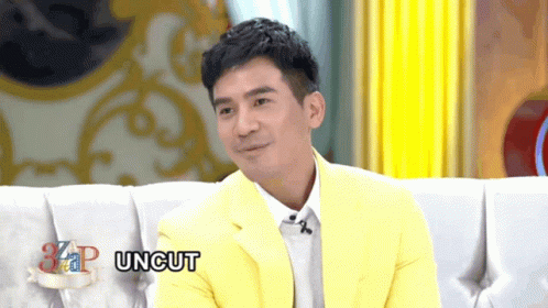 Man in Yellow Jacket Sitting on Couch Saying Uncut