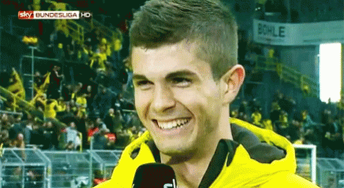 Man in Yellow Jacket Smiling Into Microphone