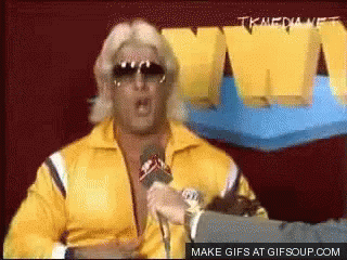 Man In Yellow Jacket Speaking Into Microphone GIF