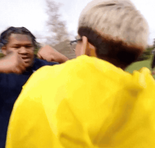 Man in Yellow Jacket Talking to Another Man
