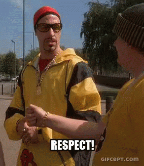 Man in Yellow Jacket Talking to Man in Sunglasses and Red Hat Respect