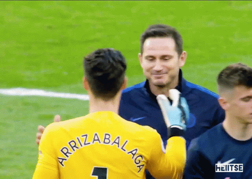 Man in Yellow Jersey Number 1 Hugging Another Man