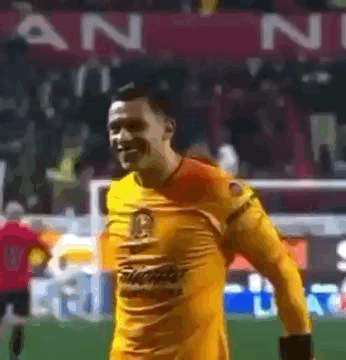 Man in Yellow Jersey Smiling on Soccer Field
