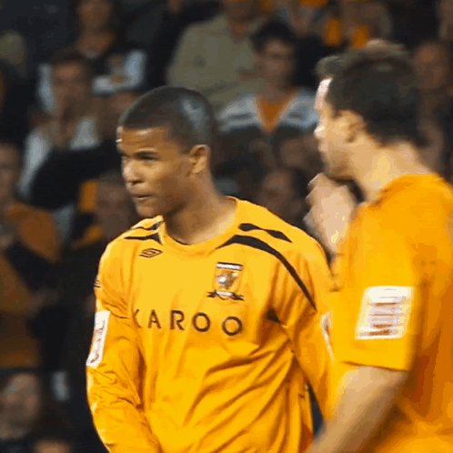 Man in Yellow Karoo Shirt Before Crowd
