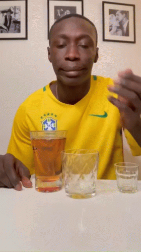 Man in Yellow Nike Shirt Sits With Two Beer Glasses