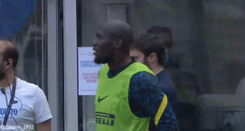 Man in Yellow Nike Vest Standing at Door