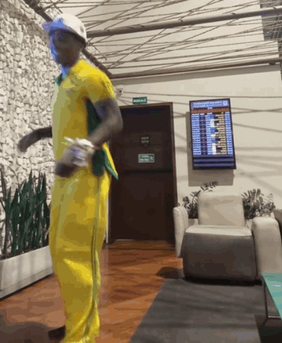 Man In Yellow Outfit Dancing Near Avenida Sign GIF