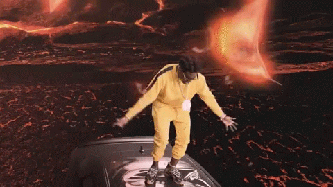 Man in Yellow Outfit Standing on Black Car