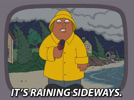 Man in Yellow Raincoat Holding Microphone
