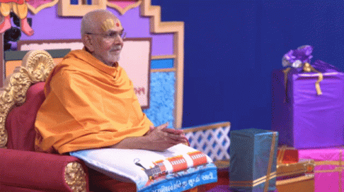 Man in Yellow Robe on Chair with Purple Box