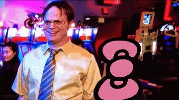 Man in Yellow Shirt and Blue Tie Smiling in Front of Hello Kitty