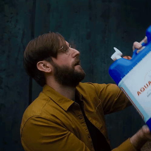 Man in Yellow Shirt Drinking Blue Xtra Container